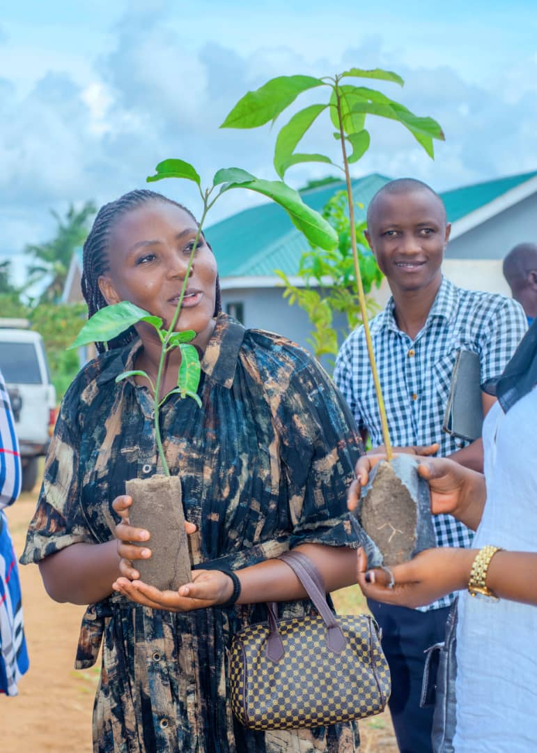 Community members holding tree seedlings ready to plant